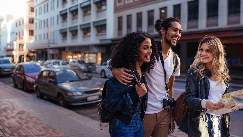 group of three young friends exploring new city
