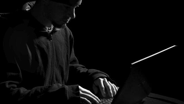 taxes-blog-silhouette-of-hacker-working-on-laptop
