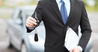 Car salesman holding keys © Syda Productions/Shutterstock.com