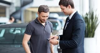Young man with car salesman © LuckyImages/Shutterstock.com