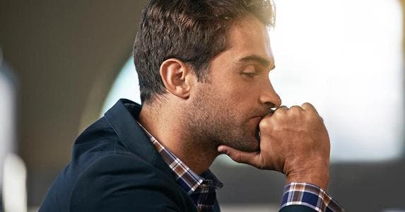 Pensive man in plaid shirt and blue jacket © iStock