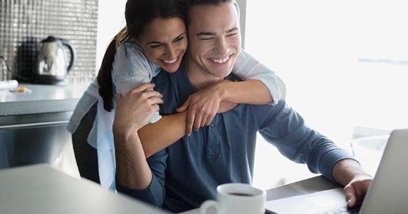 Credit unions: Where free checking still reigns Young couple hugging in kitchen | Hero Images/Getty Images