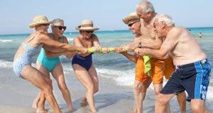 Seniors playing tug-o-war on the beach | Rolf Bruderer/Getty Images
