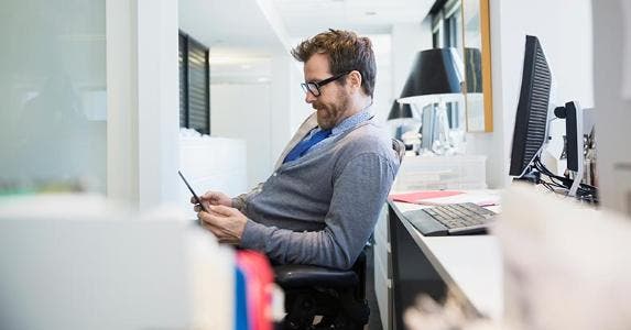 Put after-tax money in a 401(k)? Enjoy this tax break Male in grey cardigan browsing smartphone in the office | Hero Images/Getty Images