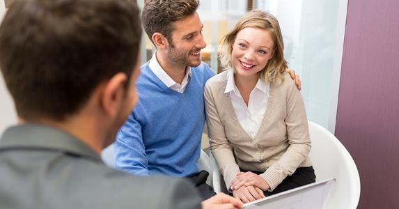 Adviser holding tablet computer, talking to clients © iStock