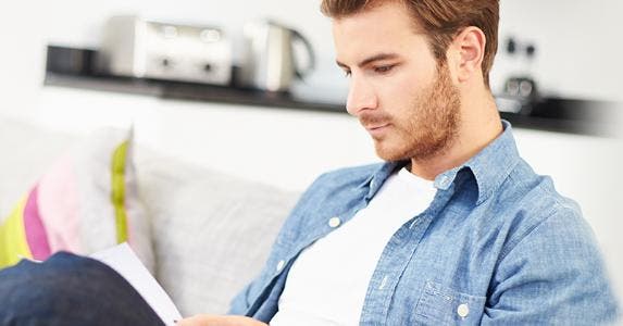 Young man looking through personal finances at home © Monkey Business Images/Shutterstock.com