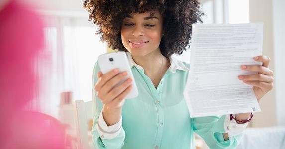 3 top mobile banking alerts: Do you have them? Woman looking at her phone | JGI/Jamie Grill/Getty Images