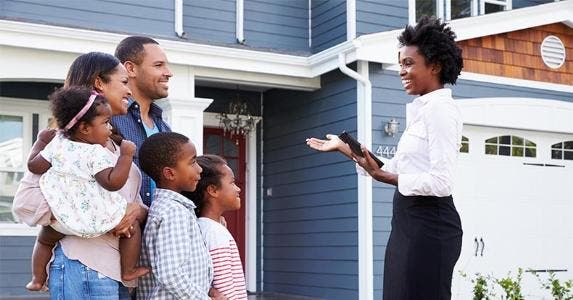 Family being shown house by realtor © Monkey Business Images/Shutterstock.com