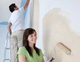 Young couple painting the walls