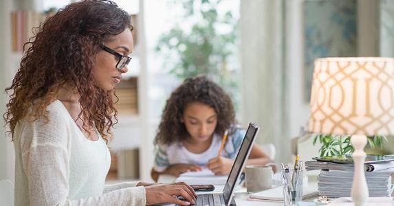 Pros and cons: Saving in an escrow account Woman working on laptop, daughter nearby | Tetra Images/Getty Images