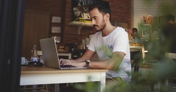 Using a laptop in the coffee shop | GaudiLab/Getty Images