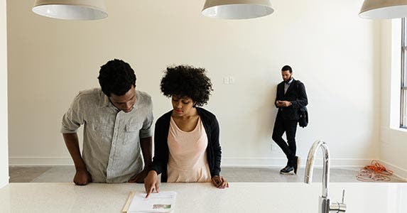 Couple looking at paperwork on the counter of empty home