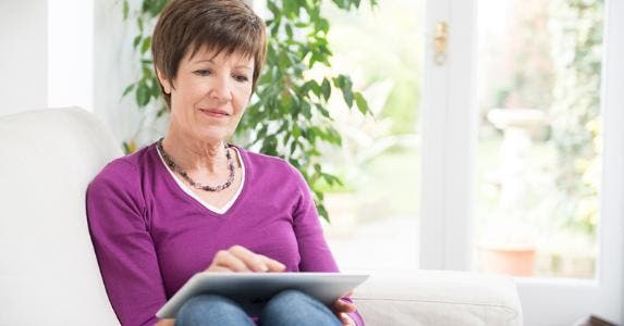 Older woman sitting with tablet on her lap © iStock