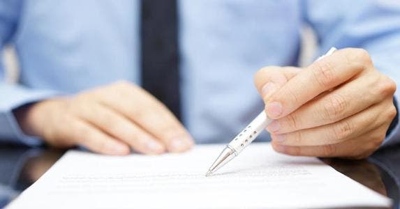I agreed to buy a home; can I change my mind? Agent pointing at contract with pen tip © iStock