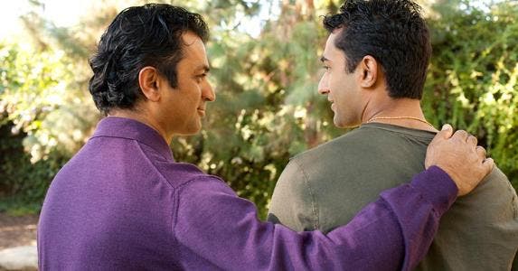 How do I buy out other half of inherited house? Two men standing outside, one hand on the other man's shoulder | iStock.com/MichaelDeLeon