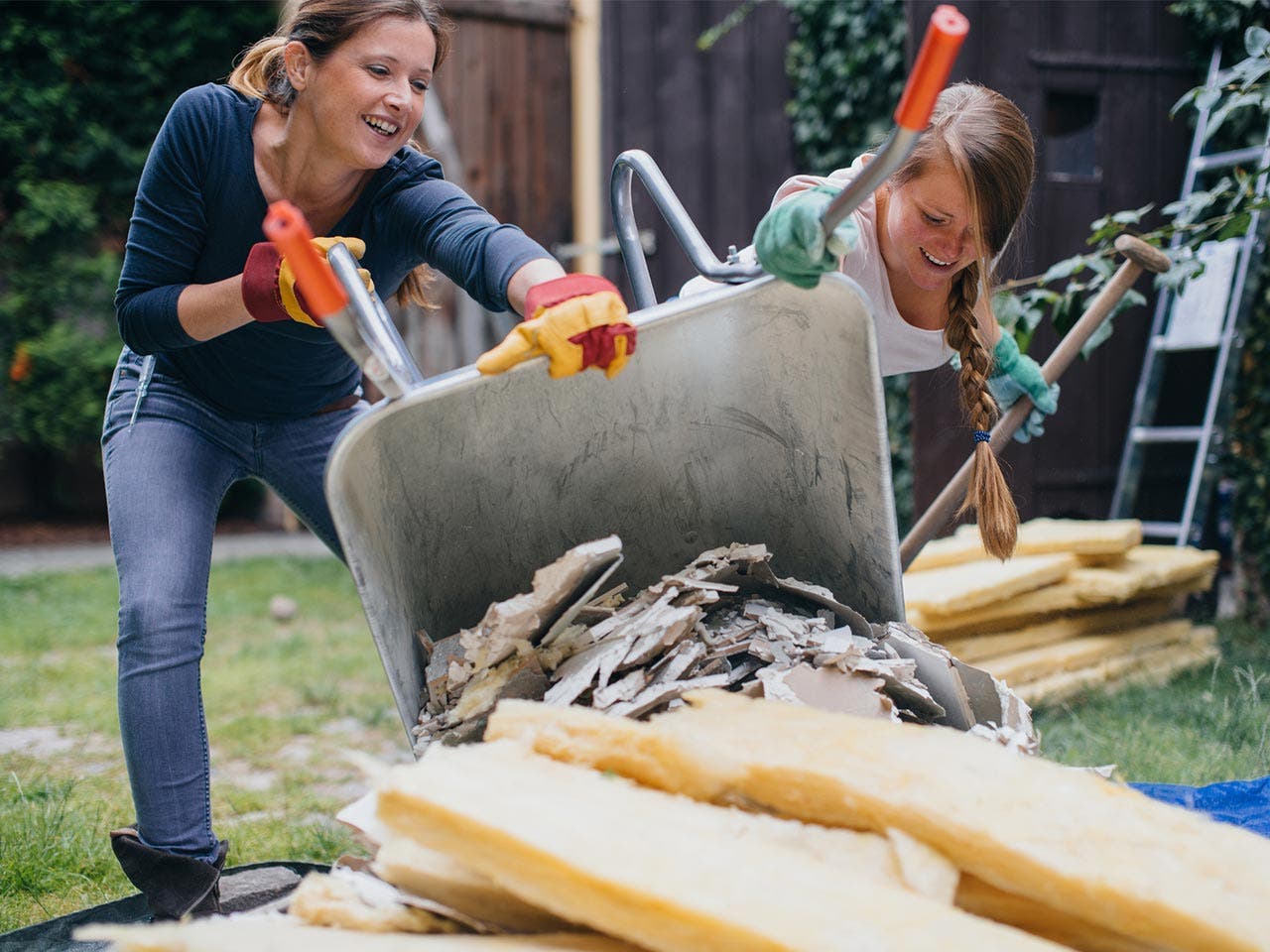 Women pouring garden scrap out of the wheelbarrow