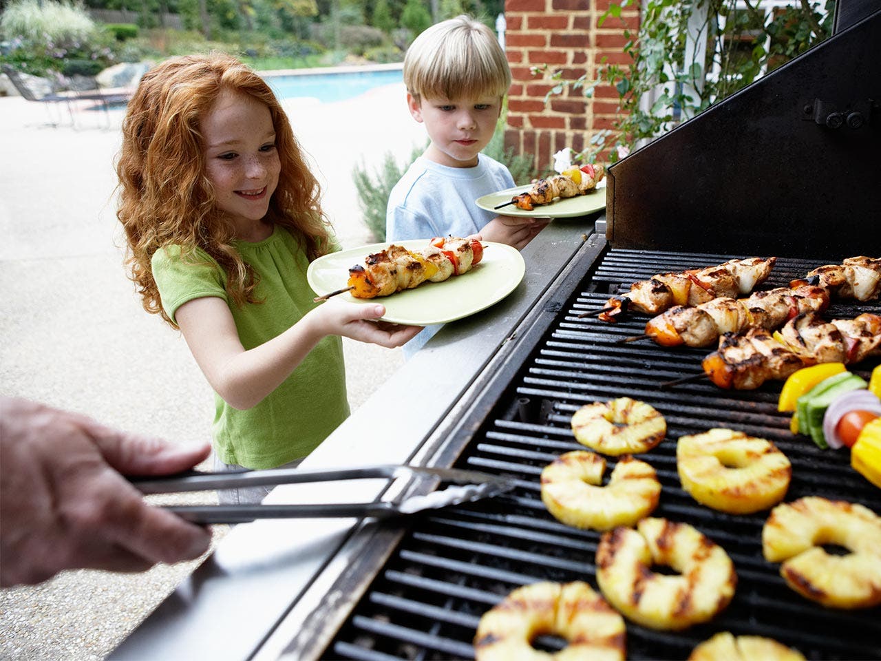 Kids taking food from grill