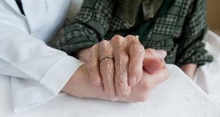 Doctor and elderly woman holding hands © sezer66/Shutterstock.com
