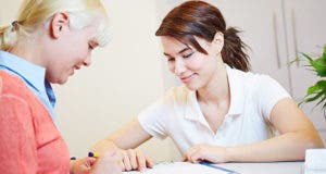 Woman filling out insurance paperwork © Robert Kneschke/Shutterstock.com
