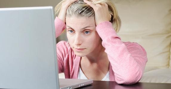 Woman holding her head in her hands © iStock