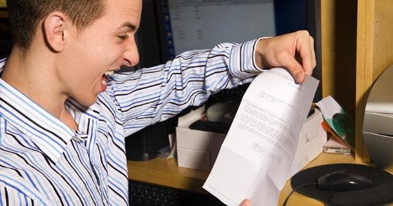 Young man frustrated at paper © iStock