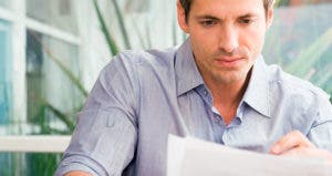 Serious man looking over paperwork © iStock
