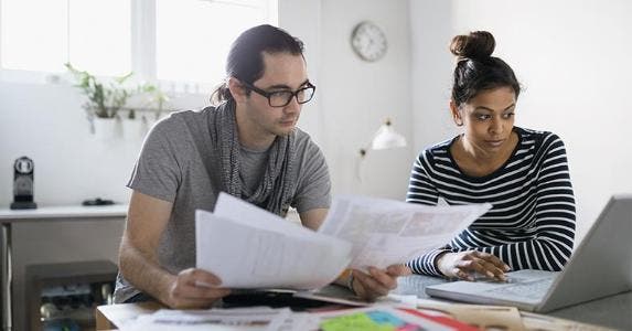 10 key tax terms to know Man and woman reading documents and browsing on laptop | Hero Images/Getty Images
