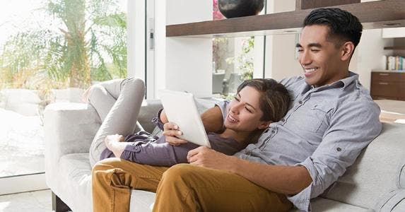 Standard or itemized deduction: Which is best for you? Couple looking at tablet on the couch | Corey Jenkins/Getty Images