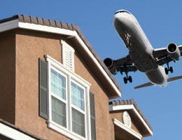 A passenger jet flying over a house