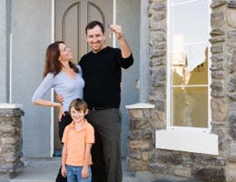 Family standing in front of a house