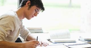 Young man writing at desk © wavebreakmedia/Shutterstock.com