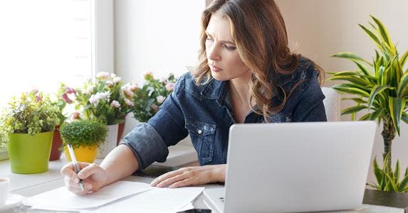 Woman wearing denim jacket filling up paperwork