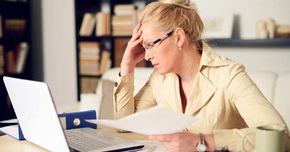 Owe tax on my portion of home deeded to siblings? Woman slumping over her home office desk © iStock