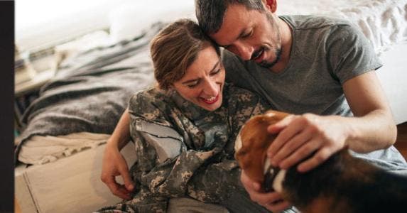 Relocating military family gets special tax break A couple petting their dog | AleksandarNakic/E+/Getty Images