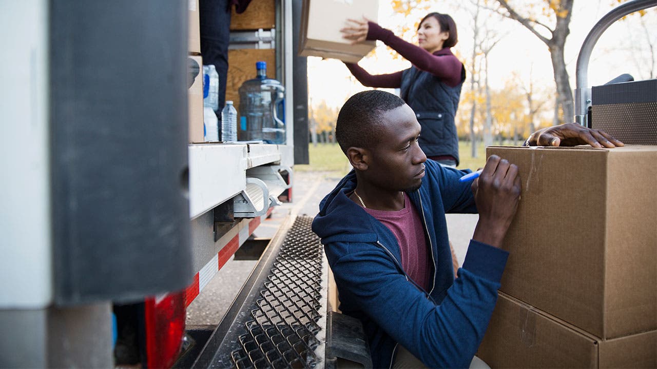 Man and woman packing boxes into moving truck