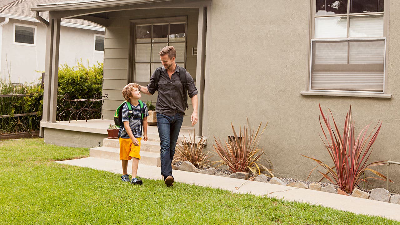 Father and son walking out of house