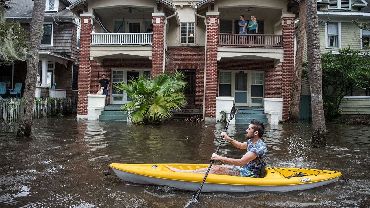 Man in Jacksonville paddles through flooding