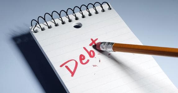 Pencil eraser erasing the word 'debt' on notebook © iStock