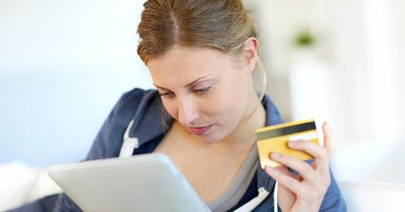 6 ways to spoil your cash-back rewards Woman reading tablet while holding a credit card © goodluz / Fotolia