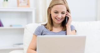 Woman talking on phone with laptop © wavebreakmedia/Shutterstock.com