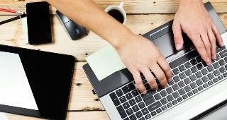 Messy desk with laptop, tablet, phone © Kostenko Maxim/Shutterstock.com