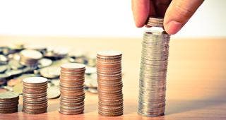 Hand stacking quarters © Singkham/Shutterstock.com