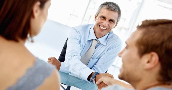 Adviser shaking hands with couple clients