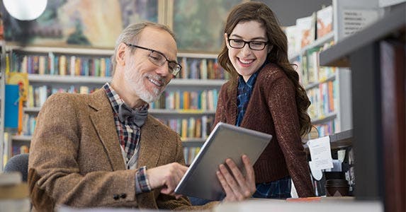 Man holding tablet as woman looks