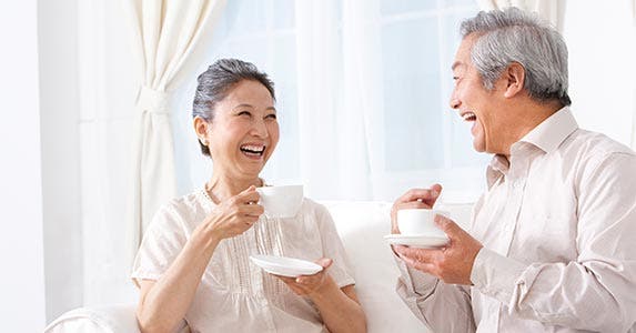 Man and woman laughing, drinking tea