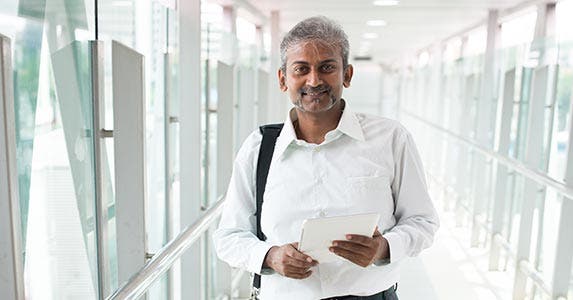 Man standing in hall holding papers