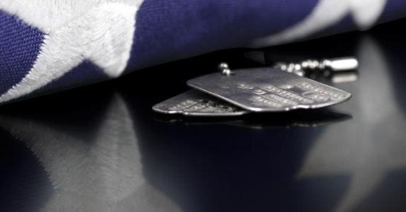 3 tactics debt collectors can't use on military Military tags and folded flag © iStock