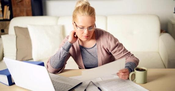 5 smart ways to simplify your finances Woman working in her home office © iStock