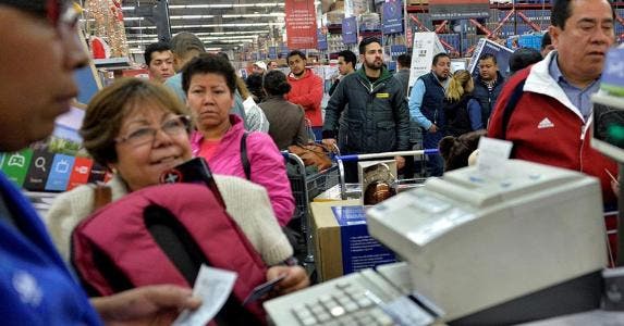 Shoppers waiting in checkout line on Black Friday | PEDRO PARDO/Getty Images