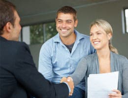 Couple shaking hands with banker
